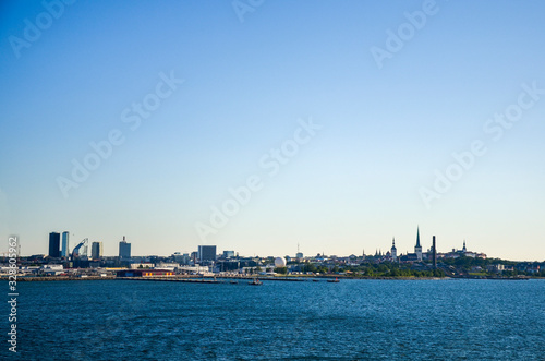  View of Old town Tallinn from cruise ship. The calm expanse of the Baltic Sea. In the distance, modern buildings the ancient cathedrals and tower on the coast. Estonia © Dmytro