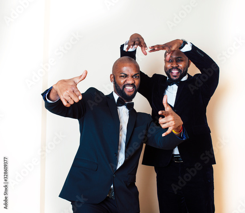 two afro-american businessmen in black suits emotional posing, gesturing, smiling. wearing bow-ties entertaiment stuff photo