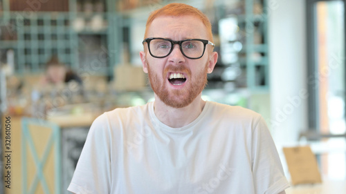 Portrait of Disappointed Redhead Man reacting to Loss