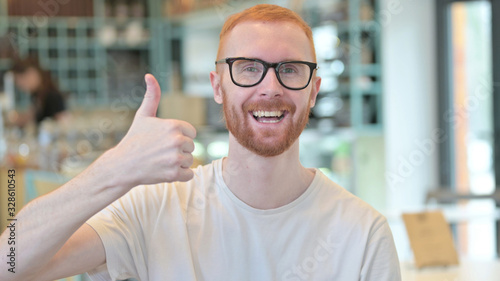 Portrait of Thumbs up by Hopeful Redhead Man
