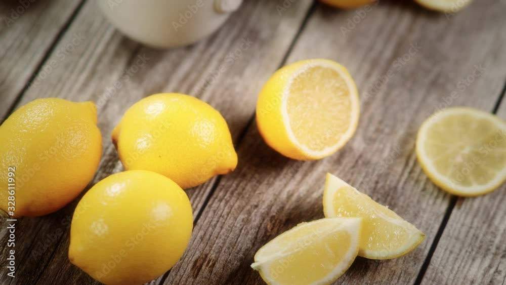 Cup of black tea with lemon slice and plenty of lemons around on grey wooden table in 4K VIDEO. Warm drink infusion for cold fall and winter days. Concept of prevention for flu cold with Vitamin C Cup of black tea with lemon slice and plenty of lemons around on grey wooden table in 4K VIDEO. Warm drink infusion for cold fall and winter days. Concept of prevention for flu cold with Vitamin C