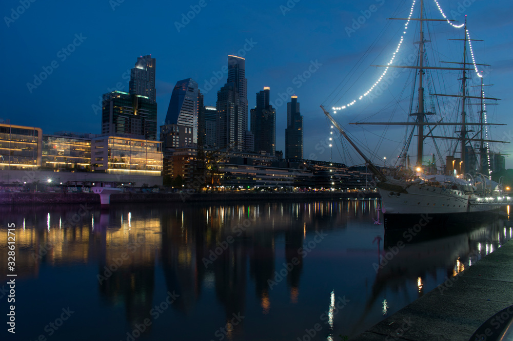 An old ship in a harbor with some building