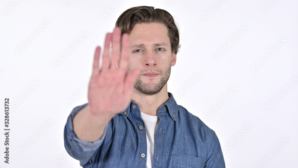 Stop Sign by Serious Young Man, Hand Gesture on White Background Stop Sign by Serious Young Man, Hand Gesture on White Background