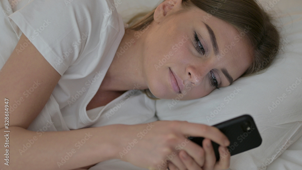Portrait of Young Woman using Smartphone in Bed Portrait of Young Woman using Smartphone in Bed