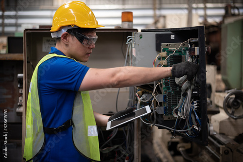 Factory technicians work on the front of the machine. © Stock_ko