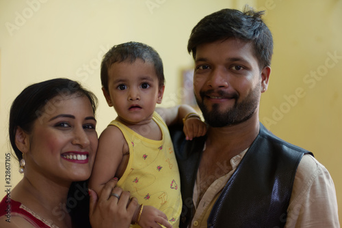 Happy Indian Bengali family with smiling mom, dad and baby. Indian lifestyle