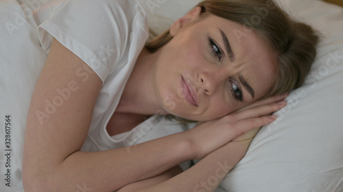 Portrait of Beautiful Young Woman Thinking in Bed