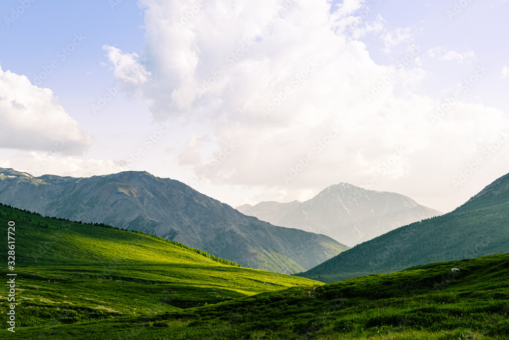 rocky ridge on horizon in mountain valley, green slopes of gentle hills, beauty of nature for relaxation and meditation rocky ridge on horizon in mountain valley, green slopes of gentle hills, beauty of nature for relaxation and meditation