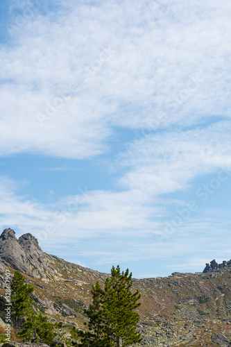 rock ridge under blue cloudy sky, mountain tourism, tourist area for relaxation © Koirill