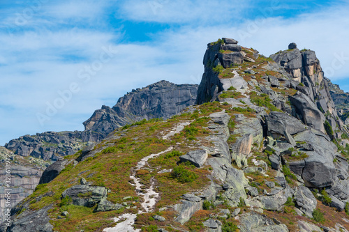 mountain trail to rock top and cliff, hiking and mountaineering on mountain ridge, symbolizes path to success, perseverance in achieving goals