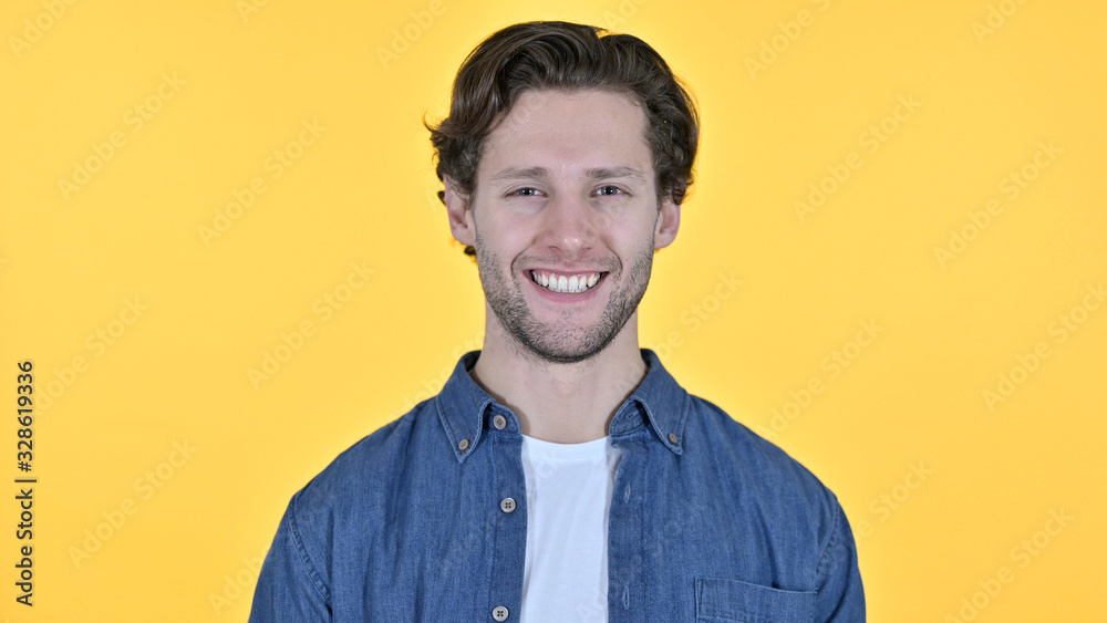 Fototapeta premium Young Man Smiling at the Camera on Yellow Background
