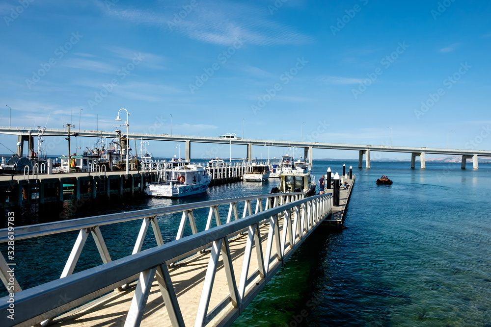 Fototapeta premium Fishing yachts parked at dock with a bridge connecting Phillip Island with San Remo area