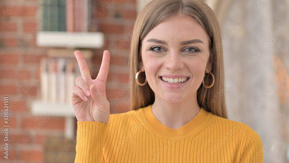 Portrait of Ambitious Young Woman showing Victory Sign