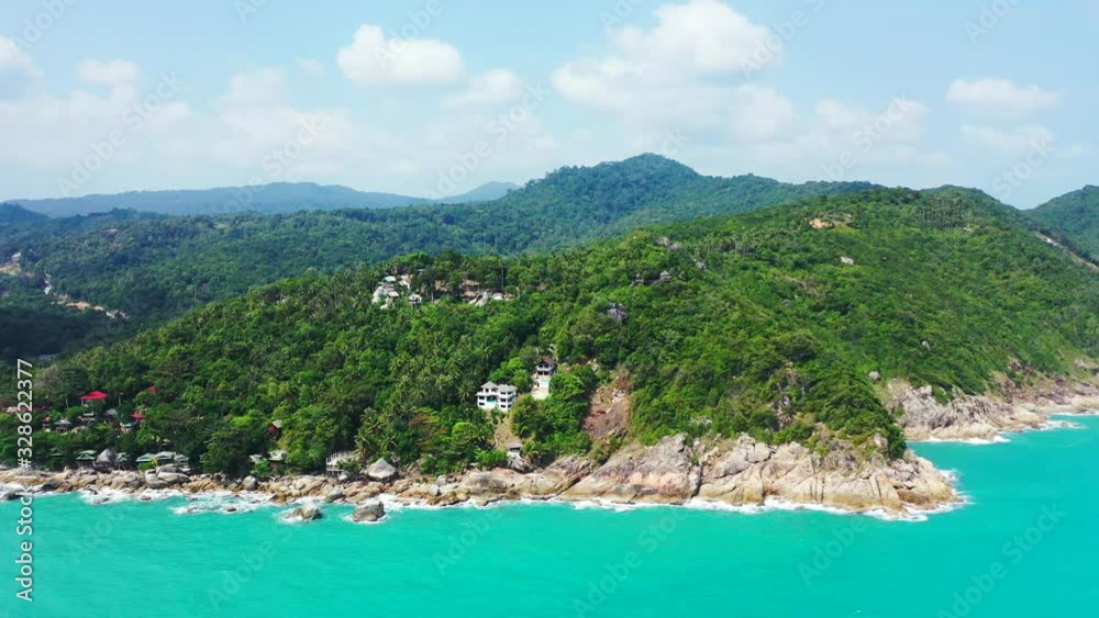 Koh Phangan rocky coast with colorful bungalows and palms on the edge of the island Koh Phangan rocky coast with colorful bungalows and palms on the edge of the island