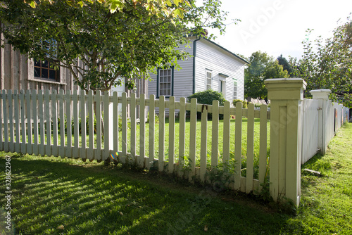 Fototapeta house exterior with white picket fence