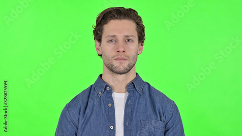 Serious Young Man Looking at the Camera on Green Chroma Key