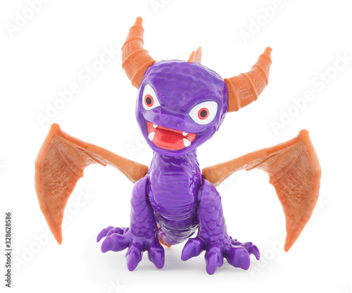 Devil plastic toy. Isolated on white background with natural shadow. Deuce with wings on white bg. Old scratch with horns and slopes. photo