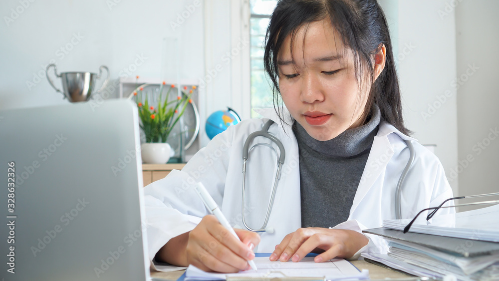 Healthcare and doctor's medical document file concept, Asian Doctor working with stethoscope, online recode patient prescriptions clipboard, input information to laptop computer on desk hospital room Healthcare and doctor's medical document file concept, Asian Doctor working with stethoscope, online recode patient prescriptions clipboard, input information to laptop computer on desk hospital room