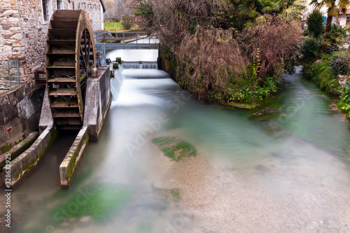 Vecchio mulino a pale caratteristico sul fiume. Borgo medioevale italiano.