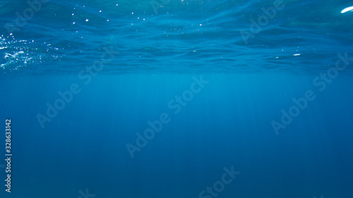 Underwater ocean background. Sea surface and sunlight