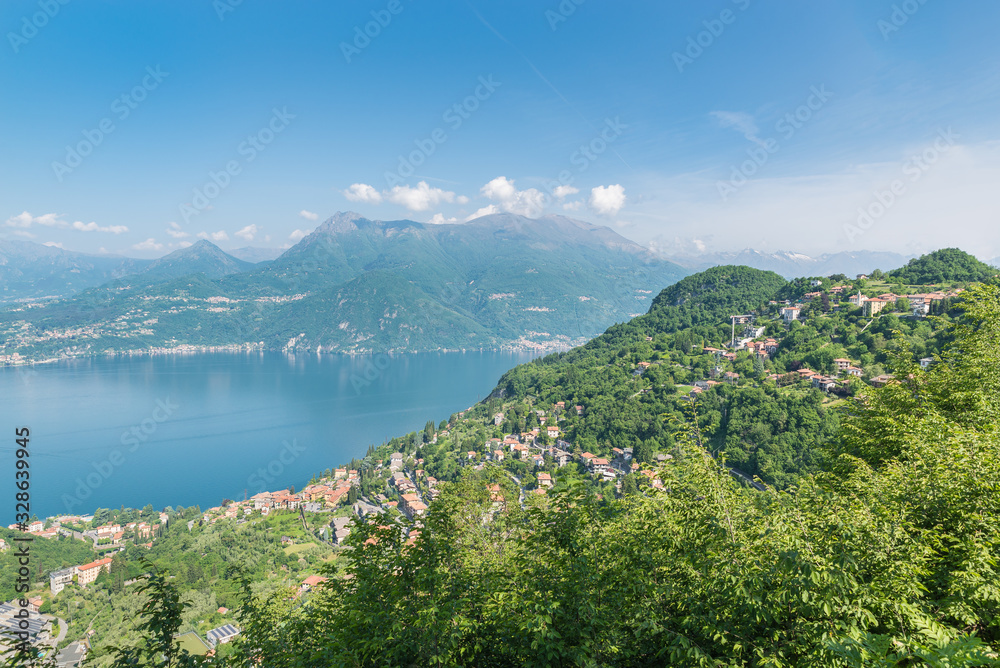 Large European lake seen from above. Lake Como, Italy with the village of Varenna at the bottom and the village of Perledo on the hill. Panorama from the road to Esino Lario