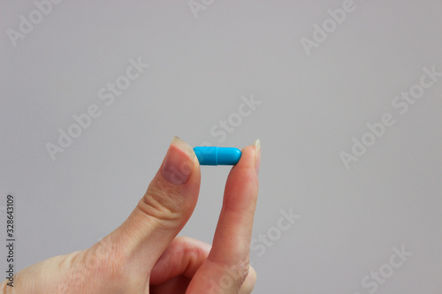 Girl holds pill in her hand