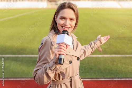 Beautiful reporter with microphone at the stadium