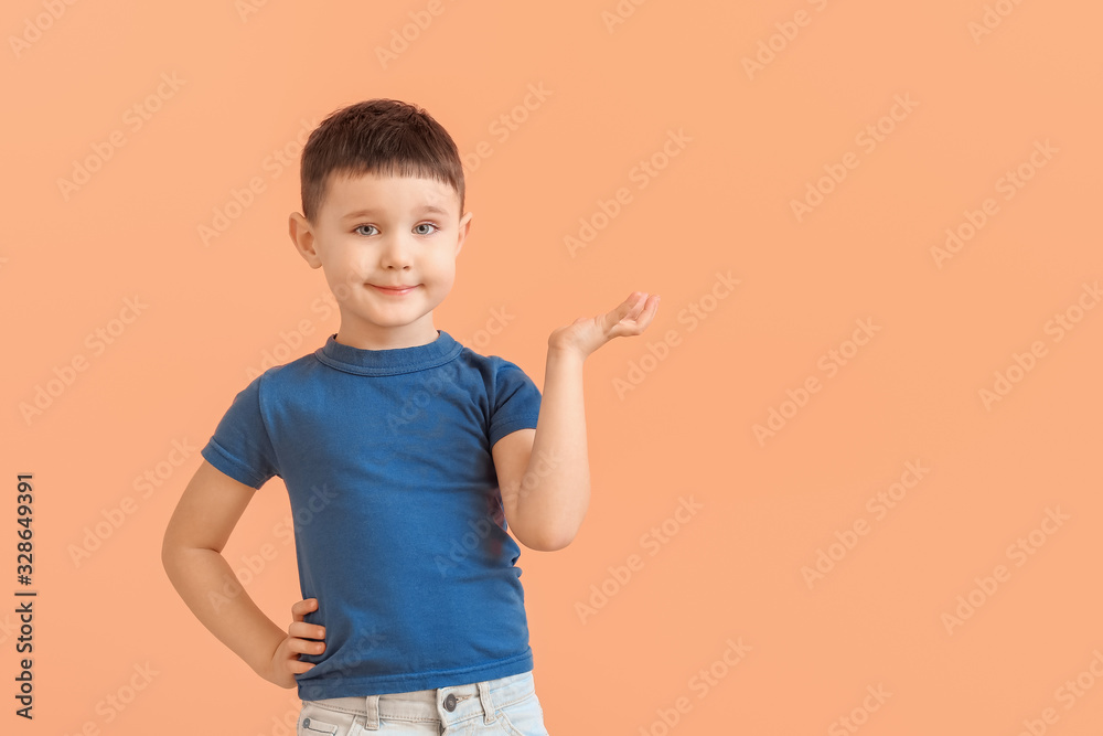 Cute little boy showing something on color background Cute little boy showing something on color background
