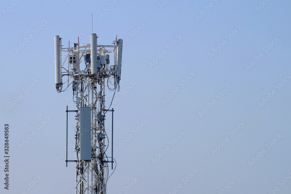 Outdoor white antenna for cellular communication on clear blue sky background