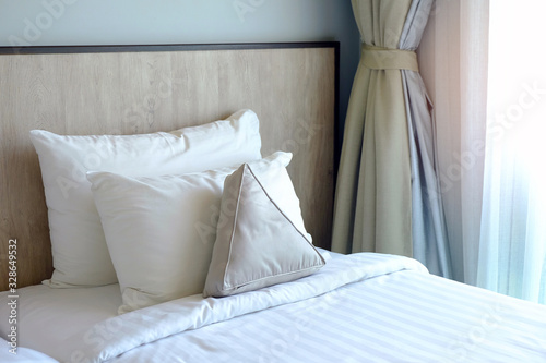 Εκτύπωση καμβά Perspective view of pillows and wooden headboard with white blanket beside the c