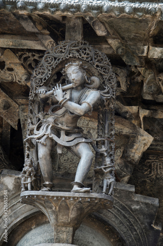 Carved sculptures on the outer wall of the Chennakeshava Temple complex, 12th-century Hindu temple dedicated to lord Vishnu, Belur, Karnataka, India photo