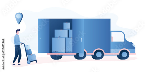 Fast delivery of goods to the buyer. Worker loads boxes in a truck. Handsome man pushes a cart with parcels.