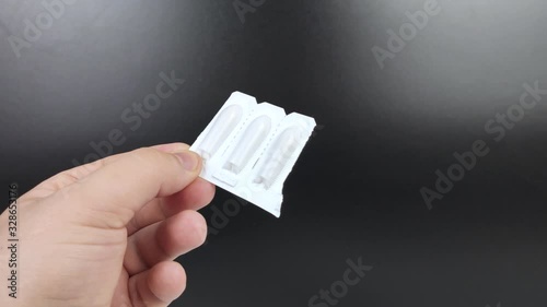 Suppositories in white packaging in the hands of a man. Macro video of rectal or vaginal suppositories before use.
