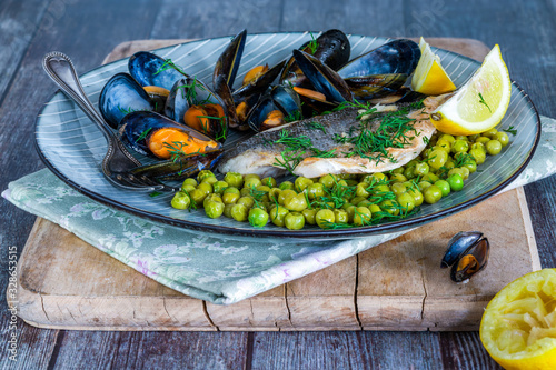 Sea bass with peas, mussels and lemon garnished with fresh dill