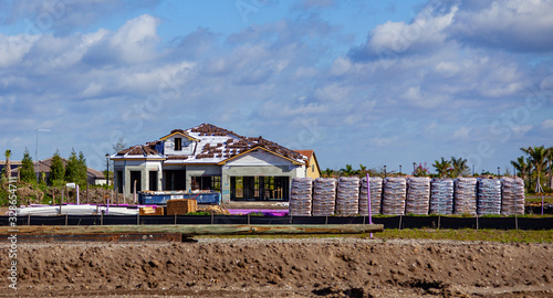 Venice FL January 30 2020 A house under construction is seen from a distance, with a large amount of building materials in the foreground. photo