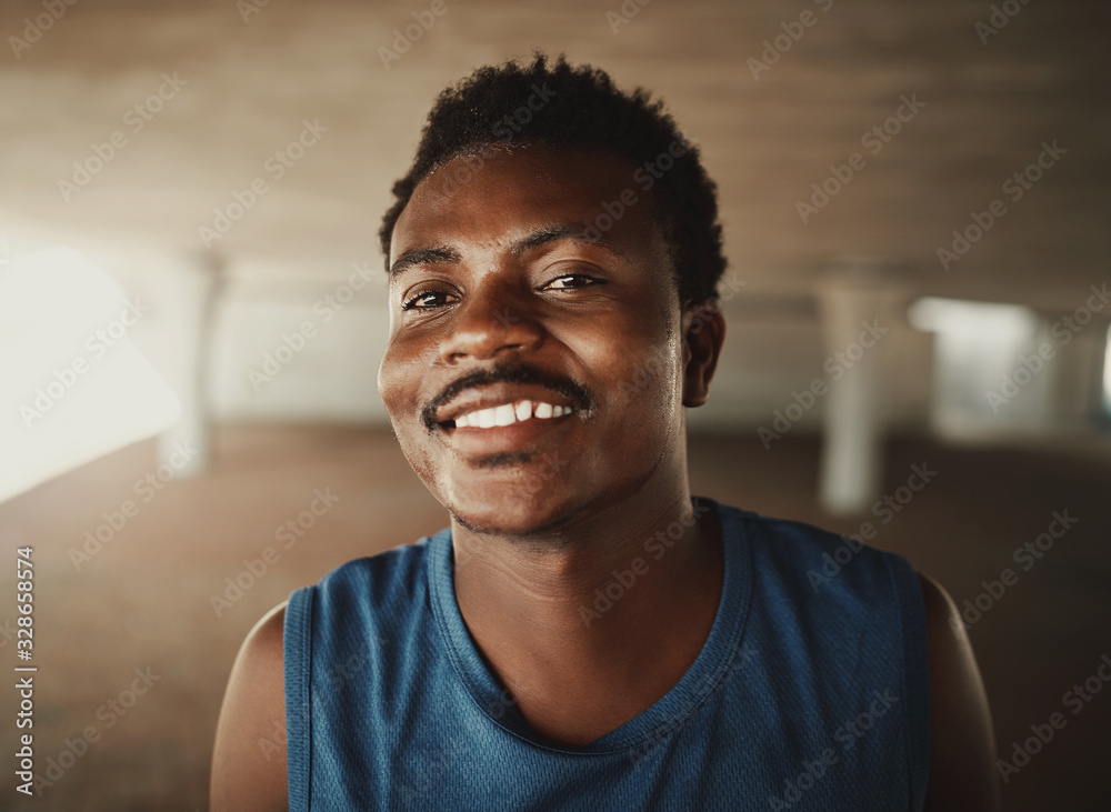 Smiling portrait of a young fitness sportive man looking to camera at outdoors Smiling portrait of a young fitness sportive man looking to camera at outdoors