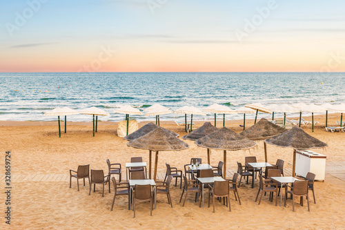 empty terrace bar on the sand of the beach by the sea at sunset. Guardamar  Alicante. Spain