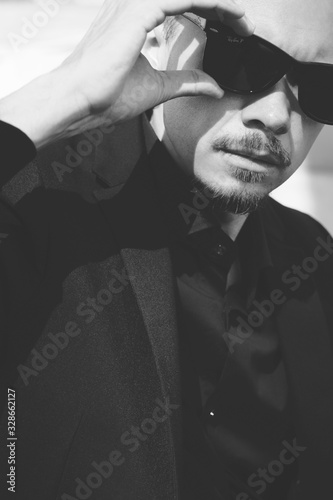 Confident man putting on sunglasses