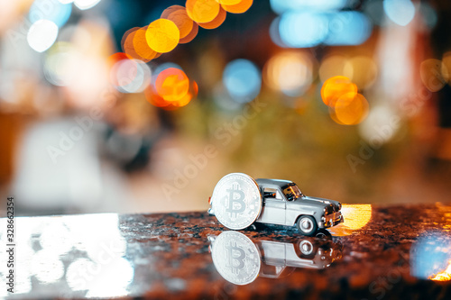 Silver bitcoin and Moskvich 401 on the table, glowing background photo