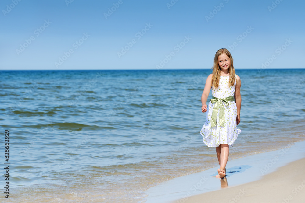 Beautiful girl in a dress walking on the beach Beautiful girl in a dress walking on the beach