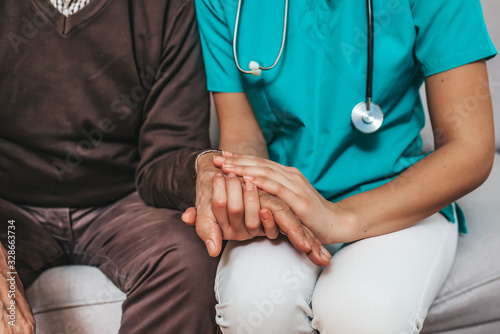 Nurse holding hand of senior man in rest home. Doctor helping old patient with Alzheimer's disease. Shot of a caregiver helping a senior man. Care Worker Helping Senior Man photo