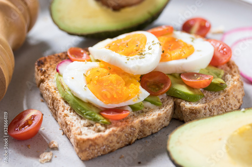 Avocado toast with boiled egg topping on a plate