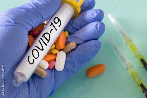 a vial of Covid-19 virus with a handful of medication in your hand in a medical glove