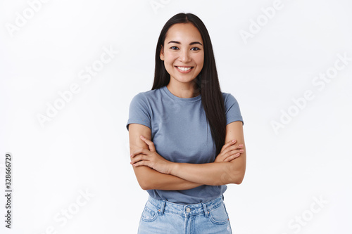 Success, beauty and lifestyle concept. Attractive asian girl in t-shirt, cross hands chest in determined, confident pose, smiling enthusiastic, feeling optimistic and assertive, white background photo
