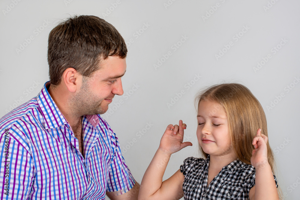 Dad and daughter spend time together. Girl cheerfully crossed her fingers on her hands and makes a wish Dad and daughter spend time together. Girl cheerfully crossed her fingers on her hands and makes a wish