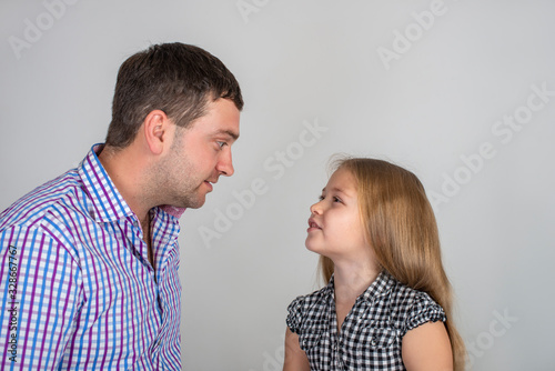 The dad and daughter  emotionally talking about something while looking at each other.