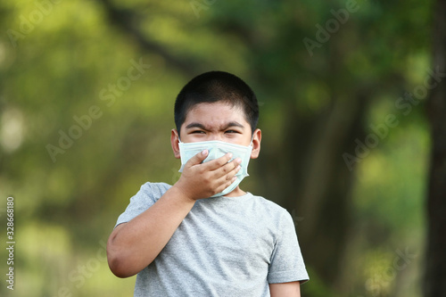 A young Asian boy , 7 Years Old , wear mask to protect against dust PM 2.5 and germs