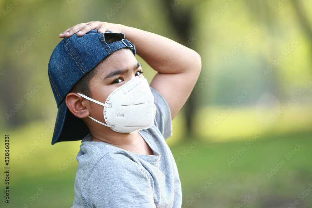 A young Asian boy , 7 Years Old , wear mask to protect against dust PM 2.5 and germs A young Asian boy , 7 Years Old , wear mask to protect against dust PM 2.5 and germs