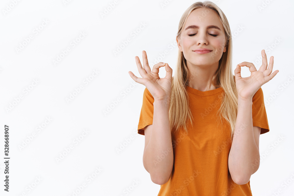 Cheerful, happy smiling caucasian woman with tattoos, close eyes and smiling relieved, feeling relaxation and joy as breathing carefree and meditating, make mudra zen sign, stand white background Cheerful, happy smiling caucasian woman with tattoos, close eyes and smiling relieved, feeling relaxation and joy as breathing carefree and meditating, make mudra zen sign, stand white background