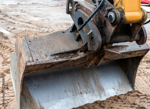 close up of dirty excavator bucket on the ground.